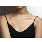 Close-up of polished cross pendant in gold-plated brass on 18-inch chain