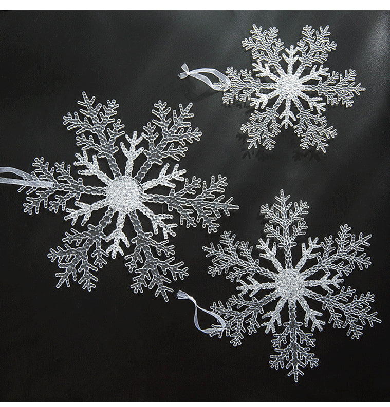 Transparent acrylic snowflake pendant hanging on a Christmas tree with red and green ornaments